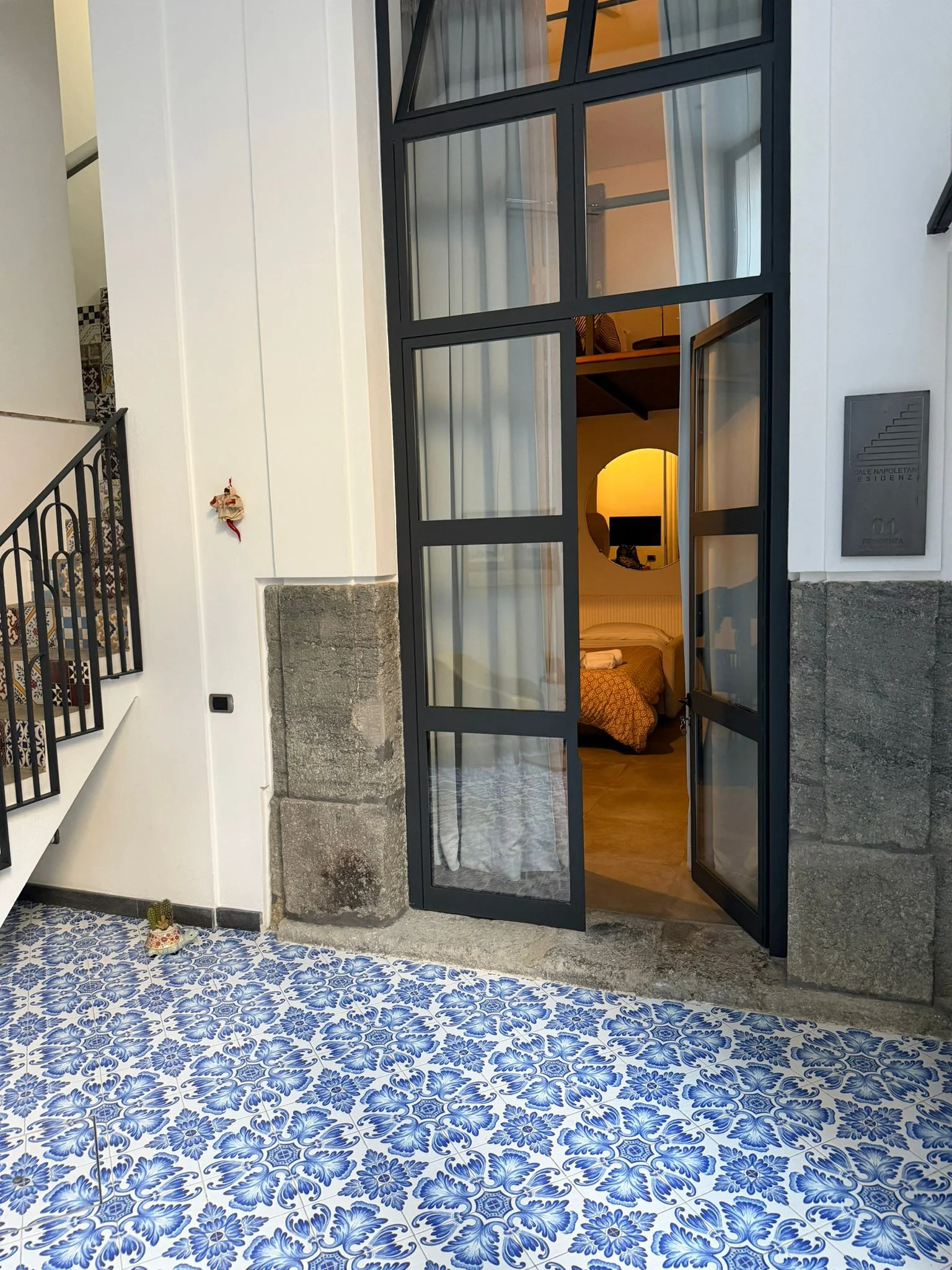 Camera Quadrupla — ingresso con maioliche blu